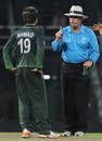 Umpire Daryl Harper warns Ahmed Shehzad not to talk too much to the batsman