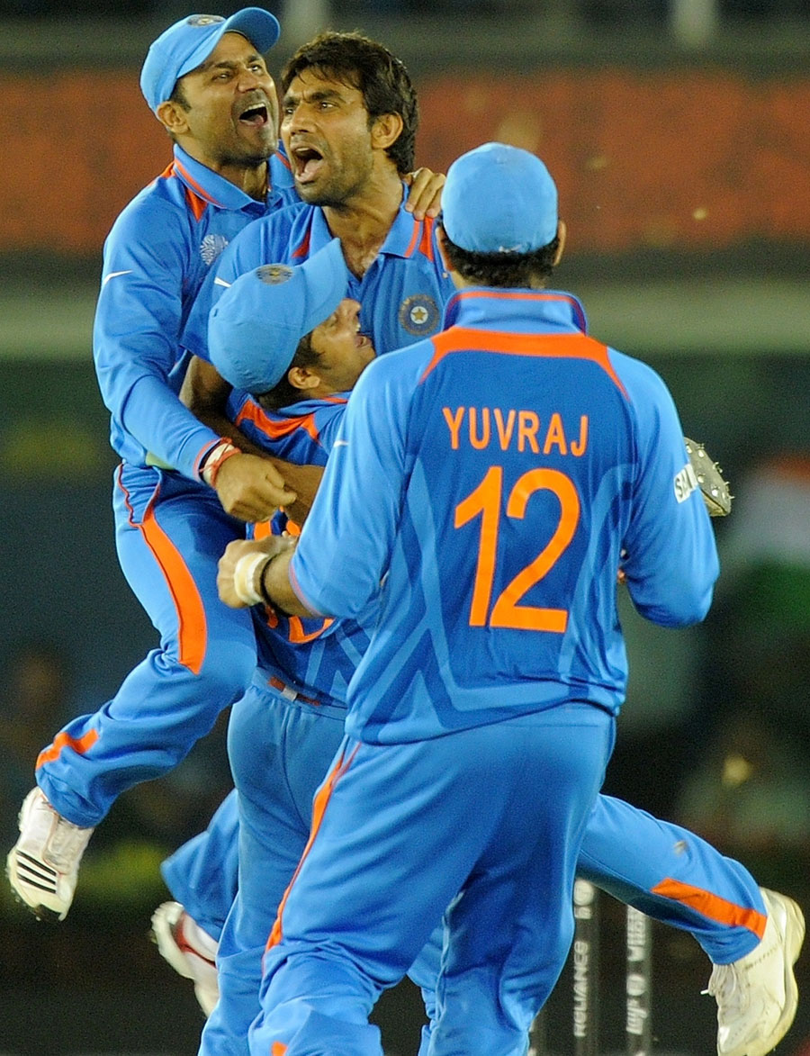 Yuvraj Singh, Virender Sehwag and Suresh Raina rush to celebrate the fall of a wicket with Munaf Patel