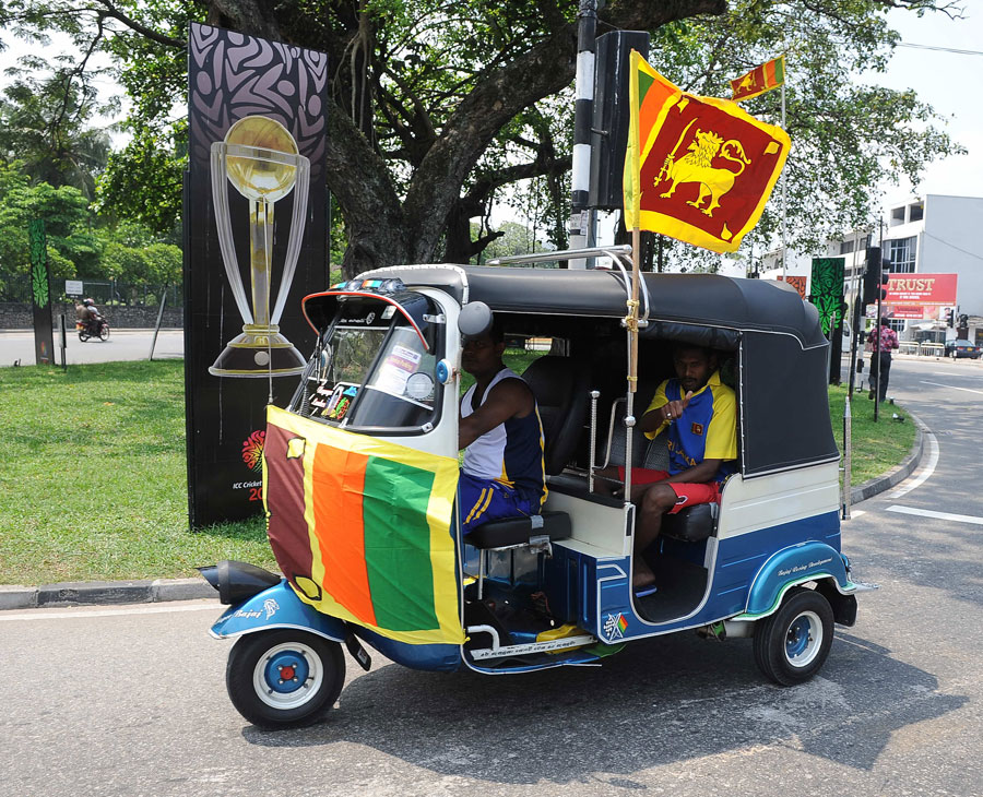An auto-rickshaw bedecked with Sri Lankan flags does the rounds in Colombo