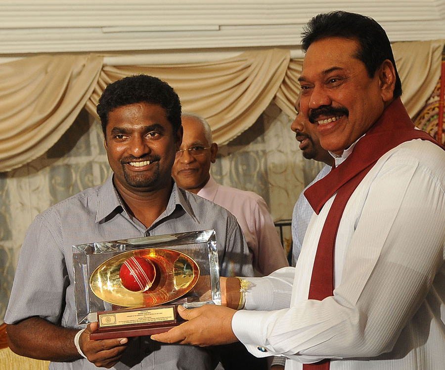 Muttiah Muralitharan is presented with a souvenir by Sri Lankan president Mahinda Rajapakse