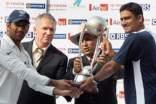 Mahendra Singh Dhoni and Anil Kumble hold aloft the series trophy presented by Allan Border and Sunil Gavaskar